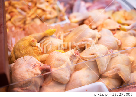 Refrigerated display case contains whole chilled chicken carcasses Refrigerated display case contains whole chilled chicken carcasses 133273009