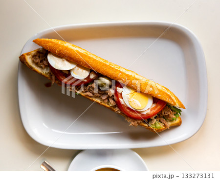 Spanish sandwich with fish and vegetables on a white plate Spanish sandwich with fish and vegetables on a white plate 133273131