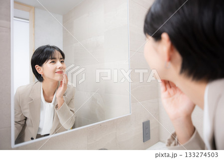 化粧など身だしなみを鏡で確認する女性 133274503