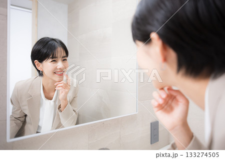 洗面所で食後に歯のチェックなど身だしなみを確認する女性 133274505