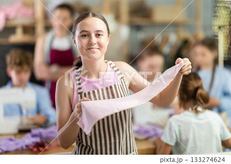 Positive teen girl child in study room of sewing school and young designers Positive teen girl child in study room of sewing school and young designers 133274624