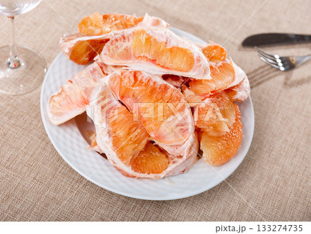 Ripe pomelo fruit slices in plate on table Ripe pomelo fruit slices in plate on table 133274735
