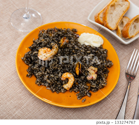 Paella is variant of dish made from black rice and seafood 133274767