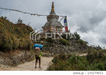 Nepali porter walking and carrying stuffed nearly Tenzing Norgay memorial stupa in Sagarmatha national park of Nepal. 133274811