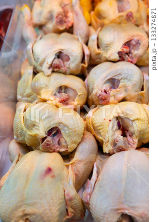 Refrigerated display case contains whole chilled chicken carcasses 133274871