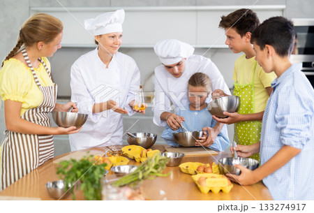 Chef apprentices learn how to properly beat eggs with a whisk in cooking class 133274917
