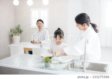 明るいキッチンで食器を洗う親子と笑顔の家族の生活シーン 明るいキッチンで食器を洗う親子と笑顔の家族の生活シーン 133275560