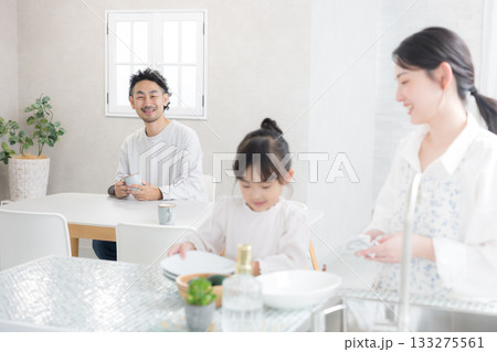 明るいキッチンで食器を洗う親子と笑顔の家族の生活シーン 133275561