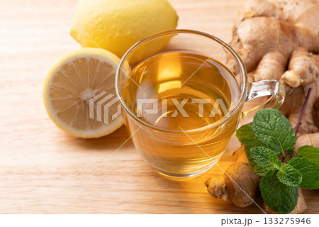 Lemon and ginger tea in cup glass with mint leaf, Healthy hot drink Lemon and ginger tea in cup glass with mint leaf, Healthy hot drink 133275946