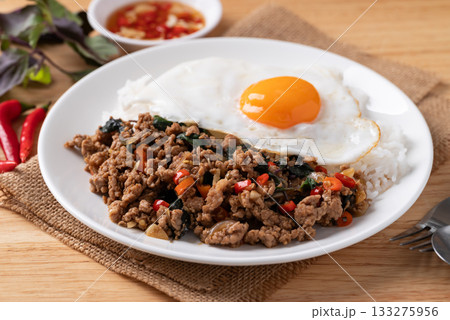 Thai food, Stir fried holy basil with minced pork with cooked rice and fried egg on top Thai food, Stir fried holy basil with minced pork with cooked rice and fried egg on top 133275956