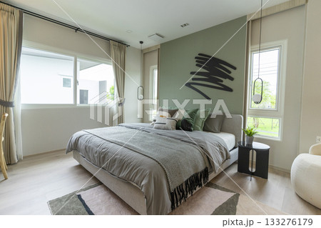 Modern bedroom interior with green wall and wall art with hanging lamp. 133276179