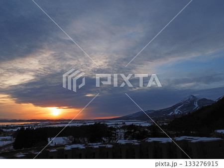冬の夕暮れ時、冠雪の磐梯山とオレンジ色に輝く猪苗代湖の湖面との間に沈む夕日が印象的で綺麗だ。 133276915