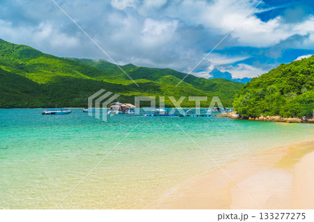 panoramic landscape with a white sandy beach in blue bay by the sea on a sunny summer day at a resort on paradise island 133277275