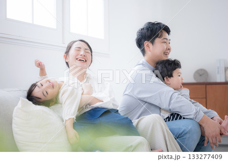 ソファで笑い合う家族の団らんと幸せの瞬間 ソファで笑い合う家族の団らんと幸せの瞬間 133277409