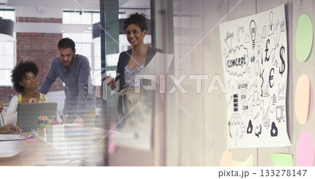 Reviewing printed documents professionals in suits collaborating in conference room with whiteboard Reviewing printed documents professionals in suits collaborating in conference room with whiteboard 133278147