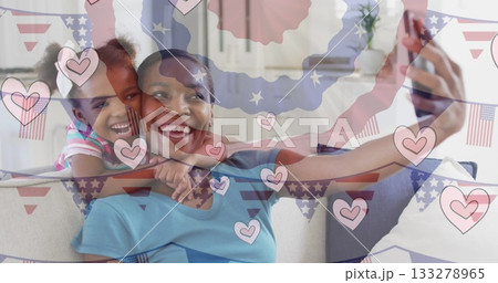 Smiling mother and daughter taking selfie on sofa at home, with smartphone digital hearts overlay Smiling mother and daughter taking selfie on sofa at home, with smartphone digital hearts overlay 133278965