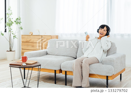 部屋でくつろぎながら音楽を聴く女性 133279702