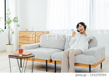 部屋でくつろぎながら音楽を聴く女性 部屋でくつろぎながら音楽を聴く女性 133279703