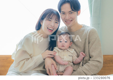 赤ちゃんを抱く夫婦 133280076