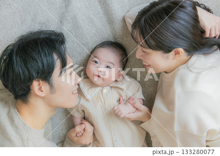 赤ちゃんを抱く夫婦 133280077