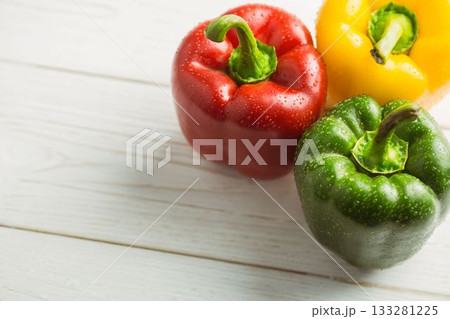 Colorful wet bell peppers on chopping board Colorful wet bell peppers on chopping board 133281225