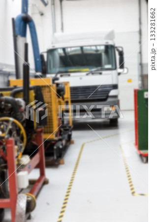 White semi-truck cab is being shown in flat design garage featuring yellow machinery, blue hoses White semi-truck cab is being shown in flat design garage featuring yellow machinery, blue hoses 133281662