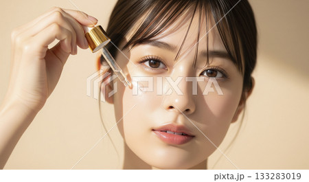 スポイトで美容液（セラム）を塗る若い日本人女性 133283019