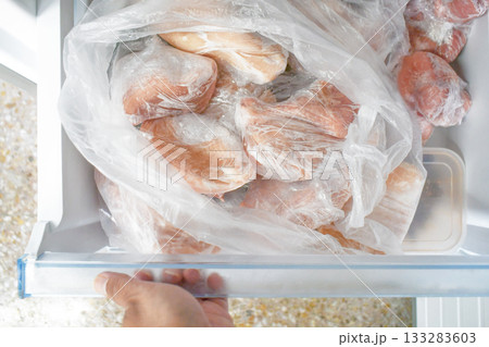 Frozen meat with plastic wrap in a the freezer. Frozen meat with plastic wrap in a the freezer. 133283603