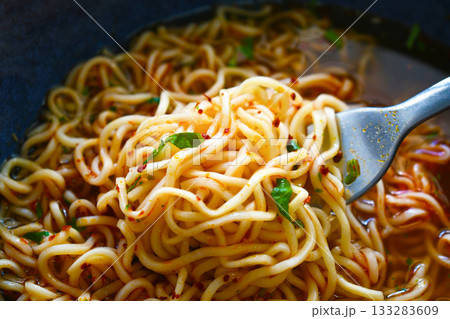 Instant noodles on fork in a bowl.  133283609