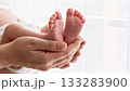 Newborn Baby Feet Close-up in Parent's Hands Gentle Touch 133283900