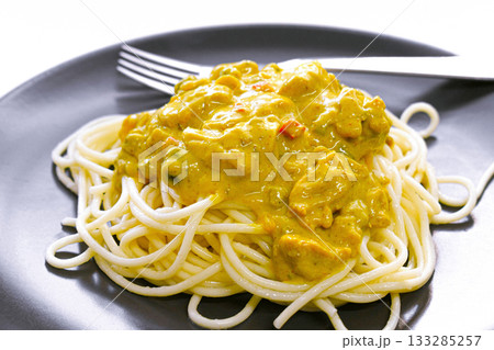 Chicken curry spaghetti with fork on a plate.  133285257