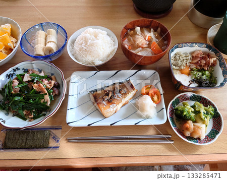 町の日本食レストランで食べる焼き魚定食のセットメニュー(鯖の塩焼き，小皿料理，椀物，デザート付き) 133285471