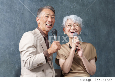 カラオケでマイクを持って歌うシニア男女 133285787