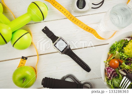 Overhead view of smart watch and dumbbells 133286363