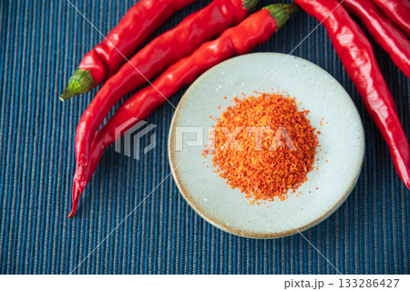 唐辛子と皿に盛った一味唐辛子 133286427
