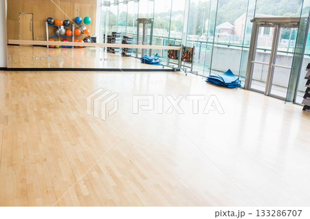 Flat design fitness studio is showing wood floor, mirrored wall, colorful balls, mats, copy space 133286707