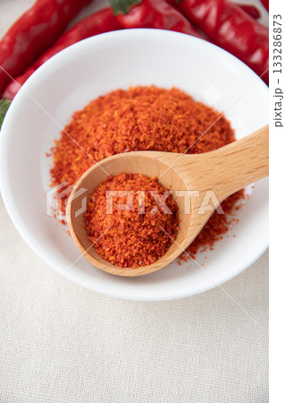唐辛子と皿に盛った一味唐辛子 133286873