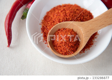 唐辛子と皿に盛った一味唐辛子 133286877