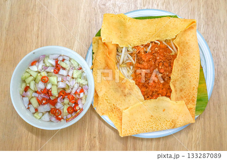The Vietnamese savory crepe common fillings include a mix of thinly sliced pork belly, shrimp, mung beans, and bean sprouts. The Vietnamese savory crepe common fillings include a mix of thinly sliced pork belly, shrimp, mung beans, and bean sprouts. 133287089