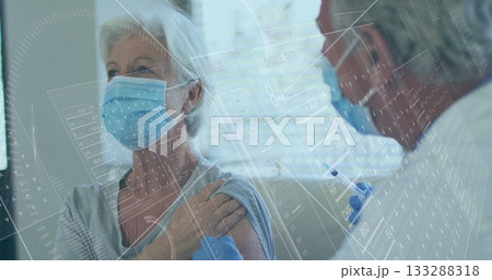 Senior patient receiving vaccine injection in clinic, with syringe gloves masks data overlay blinds 133288318