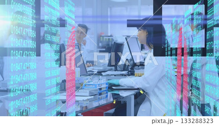 Scientist in lab coat handling test tubes, typing on keyboard at lab bench, with holographic data 133288323