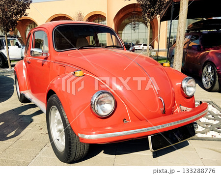 a red classic small car at an exhibition on a sunny day 133288776