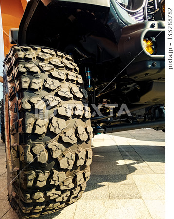 close up of a huge mud tire of an suv with deep tread 133288782