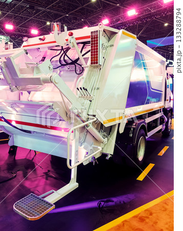 the rear part of a modern white garbage truck with a lifting mechanism at an exhibition the rear part of a modern white garbage truck with a lifting mechanism at an exhibition 133288794