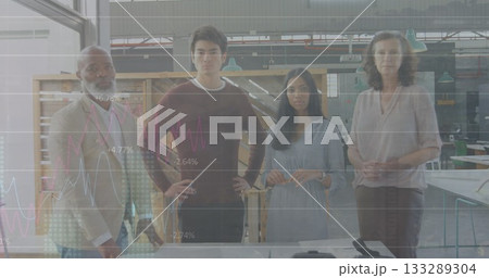 Standing diverse team of four professionals analyzing graph overlays in makerspace, with worktable 133289304