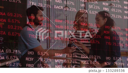 Three coworkers pouring coffee and showing phone at office countertop, with steel pot, ID badges 133289336