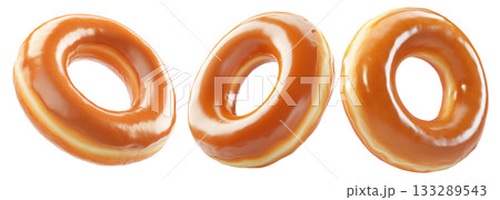 Tasty round donut topped with caramel and vanilla glaze swirl, isolated on white transparent background 133289543