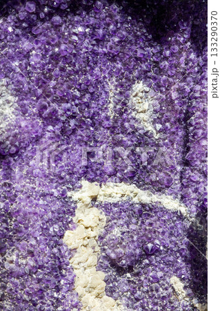 Amethyst geode in macro view with purple quartz points and white minerals forming texture Amethyst geode in macro view with purple quartz points and white minerals forming texture 133290370