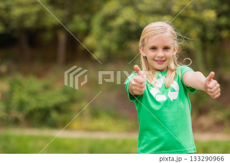 Girl standing in clearing wearing green t-shirt with recycling symbol giving thumbs up, copy space Girl standing in clearing wearing green t-shirt with recycling symbol giving thumbs up, copy space 133290966