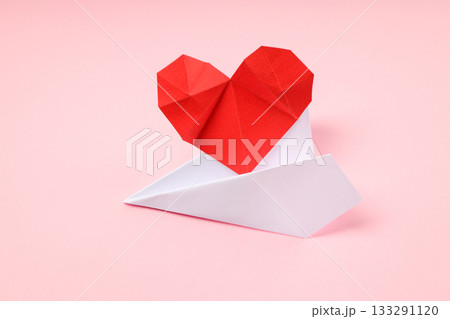 Red and white origami heart on a paper airplane Red and white origami heart on a paper airplane 133291120